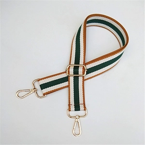 Detail of adjustable wide canvas shoulder strap with green stripes and gold metal hooks
