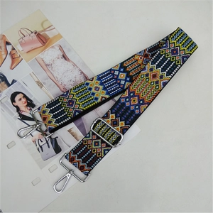 Ethnic style woven replacement bag strap with adjustable metal buckle on white background