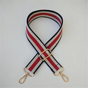 Detail of adjustable red white and blue striped canvas bag strap with gold metal hooks