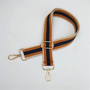 Detail of adjustable striped bag strap with gold lobster clasps and metal buckle