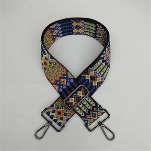 Detail of adjustable colorful ethnic woven bag strap with geometric patterns and metal hooks