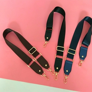 Close-up of adjustable nylon bag straps in brown, green, and blue with gold metal hooks