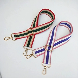 Detail of adjustable colorful striped bag strap with gold metal lobster clasps and buckles