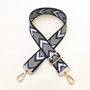 Detail of adjustable blue chevron pattern bag strap with gold metal lobster clasps