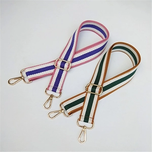 Detail of adjustable striped bag straps with gold metal hooks and hardware