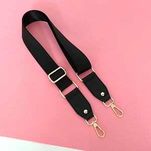 Detail of black nylon shoulder strap with gold metal buckle and swivel hooks