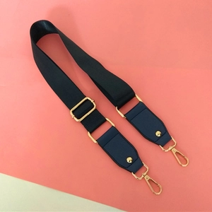 Close-up of adjustable dark blue nylon strap with gold hardware and leather details
