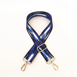 Detail of adjustable wide shoulder strap with ethnic blue woven pattern and gold buckles