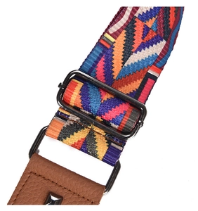 Macro detail of geometric patterned bag strap with leather ends and silver pyramid studs