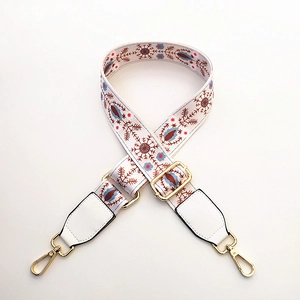 Close-up of ethnic floral embroidery wide strap with gold metal lobster clasps