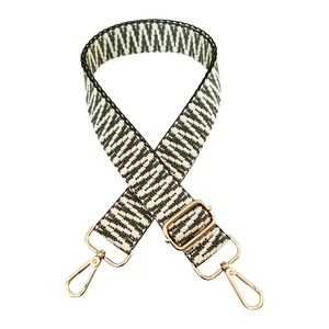 Macro detail of geometric jacquard shoulder strap with gold metal swivel hooks