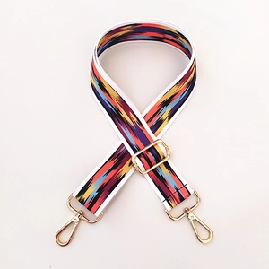 Detail of adjustable colorful ethnic geometric strap with gold metal hooks and buckles
