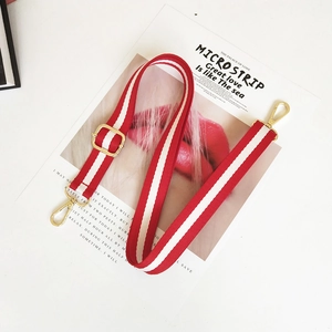 Detail of red and white striped canvas strap with adjustable golden metal hardware