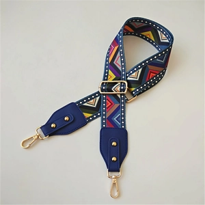 Close-up of ethnic geometric pattern woven strap with gold buckle and lobster clasp