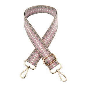 Detail of pink and grey geometric woven guitar strap with gold metal buckle