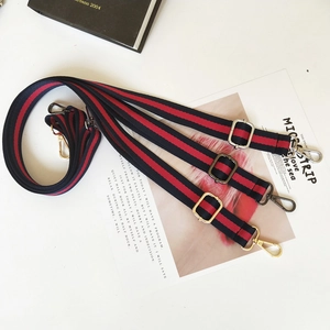 Adjustable striped canvas straps with gold, silver, and black hardware hooks detail