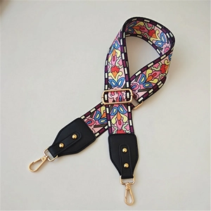 Detail of colorful ethnic floral wide bag strap with gold metal hooks and leather ends