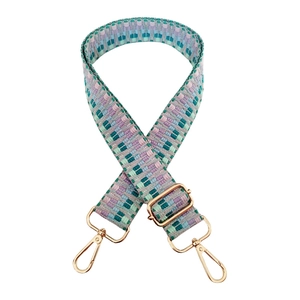 Close-up of geometric woven bag strap with golden metal lobster clasps and slider buckle