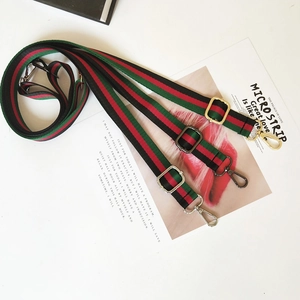 Detail of adjustable green and red striped canvas straps with multi-color metal buckles
