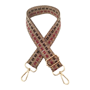 Detail of adjustable woven bag strap with geometric checkerboard pattern and gold hooks