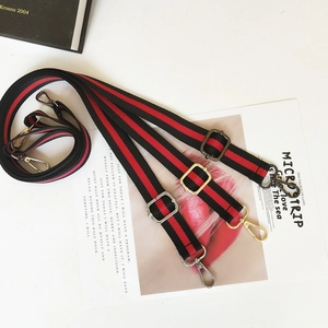 Close-up of adjustable striped canvas bag straps with gold, silver and bronze hardware