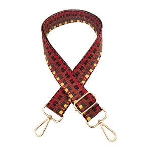 Detailed view of bohemian woven bag strap with colorful patterns and golden lobster clasps