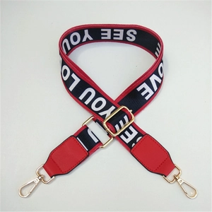 Detail eines rot-schwarzen breiten Taschenriemens mit SEE YOU LOVE Text und Goldhaken