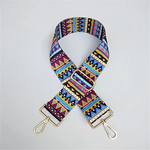 Détail de la bandoulière large colorée à motifs géométriques et boucles dorées