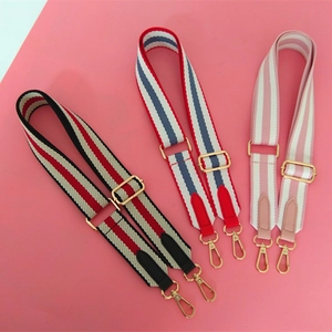 Detailed view of adjustable wide striped bag straps with gold metal hooks in three colors
