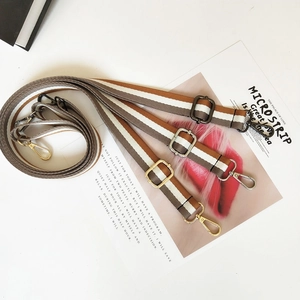 Detail view of adjustable striped canvas bag straps with premium metal swivel hooks