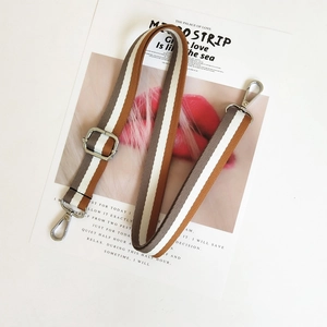 Macro detail of adjustable striped bag strap with durable silver metal swivel lobster hooks