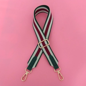 Adjustable wide canvas bag strap with green, red, and white stripes and gold metal hooks