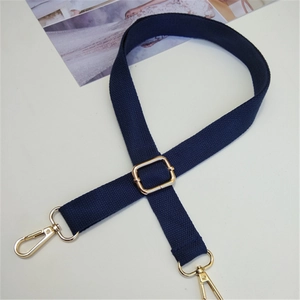 Dettaglio della tracolla regolabile in cotone blu navy con fibbie in metallo dorato