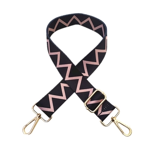 Close-up of adjustable wide woven shoulder strap with pink zigzag pattern and gold hooks