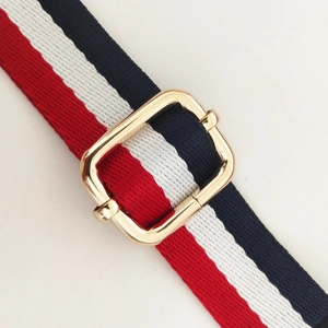 Macro view of adjustable 2.5cm red white and blue striped fabric bag strap with gold buckle