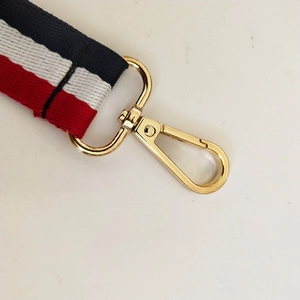 Detail of red white and blue striped bag strap with premium gold metal lobster clasp