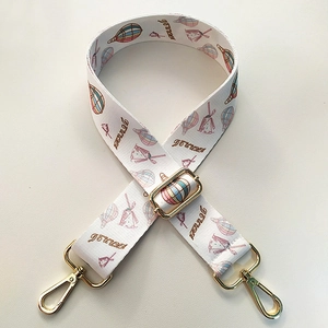 Detail view of colorful dream balloon patterned wide shoulder strap with gold metal hooks