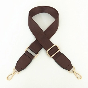 Detail of dark brown thick nylon strap with shiny gold swivel hooks and adjustment buckle