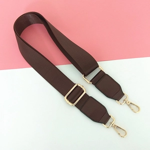 Detail of dark brown adjustable nylon shoulder strap with gold metal lobster clasps
