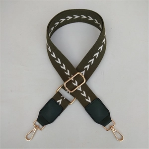 Close-up of olive green herringbone wide bag strap with gold lobster clasps and buckle