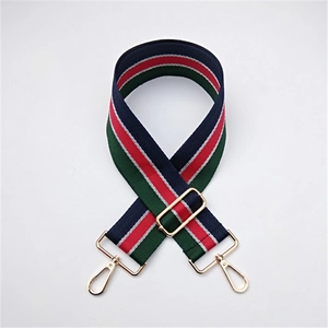 Close-up of adjustable striped handbag strap with navy, red, green, and gold hardware