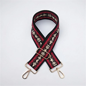 Detail of ethnic style red and black embroidered bag strap with golden metal swivel hooks