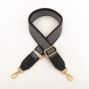 Adjustable black and white herringbone embroidered bag strap with gold metal hooks