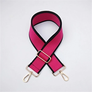 Close-up of adjustable pink and black ethnic wide guitar strap with golden metal buckles