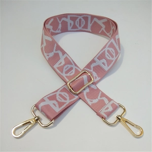 Detail of adjustable pale pink embroidered purse strap with golden metal lobster clasps