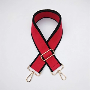 Close-up of red and black adjustable wide canvas bag strap with gold metal hooks