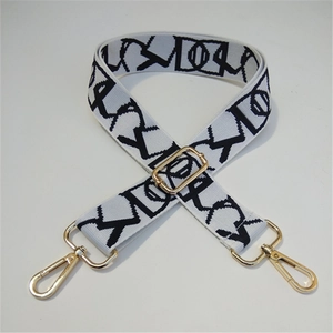 Macro detail of adjustable woven crossbody strap with geometric pattern and gold clasps