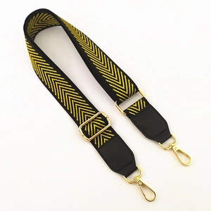 Detail of yellow chevron woven strap with gold metal buckles and black leather connectors