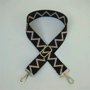 Detail of adjustable woven bag strap with golden lobster clasp and zigzag pattern