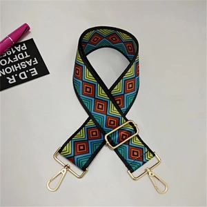 Close-up of geometric pattern shoulder strap with golden metal swivel hooks and buckles